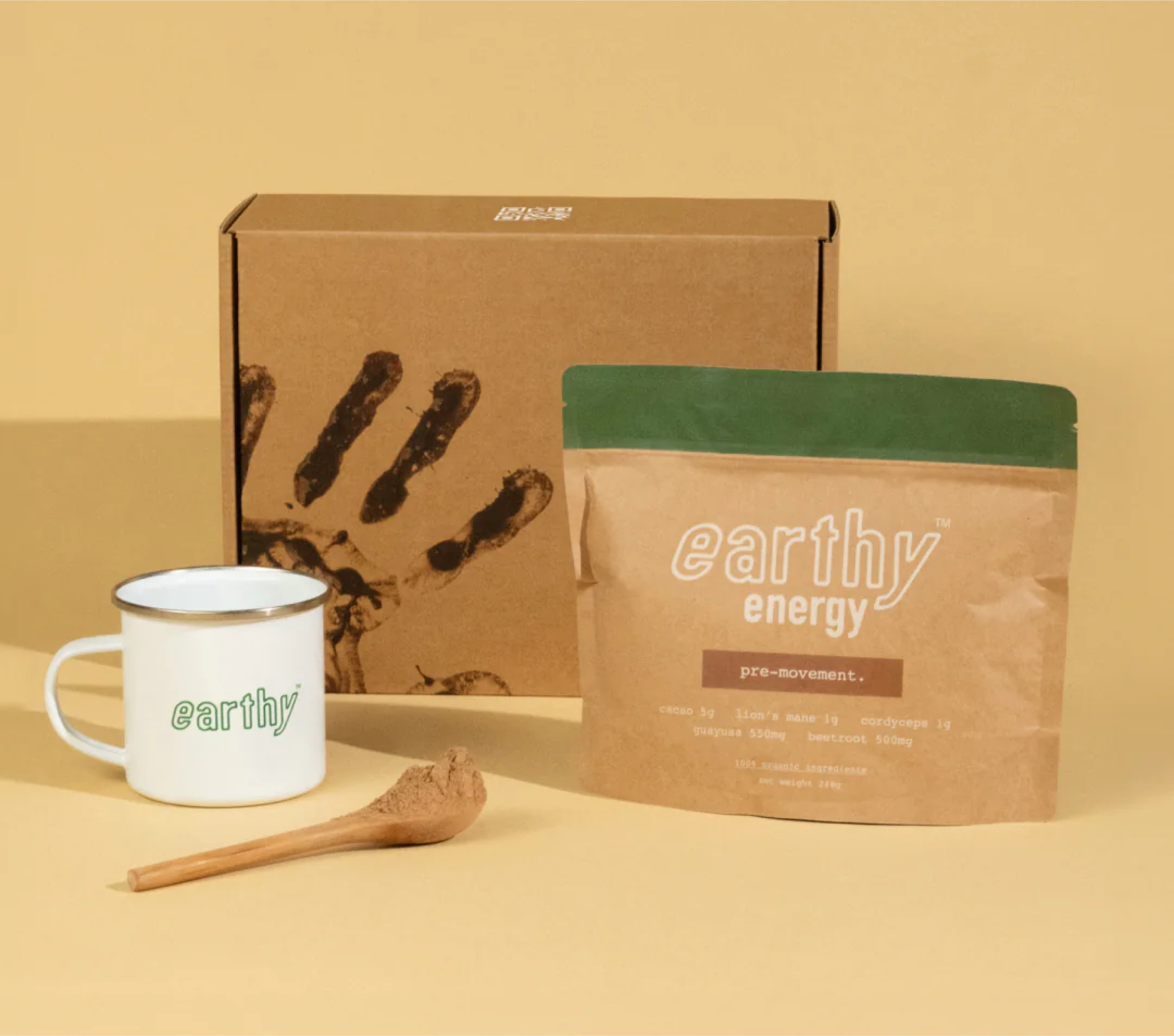 Branded mug, package of 'earthy energy' product, and wooden scoop on a yellow background.